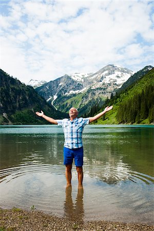 simsearch:600-07192155,k - Mature man with arms stretched outward, standing in Lake Vilsalpsee, Tannheim Valley, Austria Stock Photo - Premium Royalty-Free, Code: 600-06841891