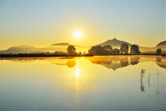 Wachsenburg Castle with Morning Mist and Sun reflecting in Lake at Dawn, Drei Gleichen, Thuringia, Germany Stock Photo - Premium Royalty-Free, Artist: Raimund Linke, Image code: 600-06899716
