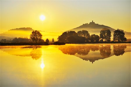 Wachsenburg Castle with Morning Mist and Sun reflecting in Lake at Dawn, Drei Gleichen, Thuringia, Germany Foto de stock - Royalty Free Premium, Número: 600-06899717