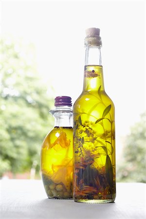 Still life of bottles of olive oil with herbs on window sill, Germany Photographie de stock - Premium Libres de Droits, Code: 600-06899766