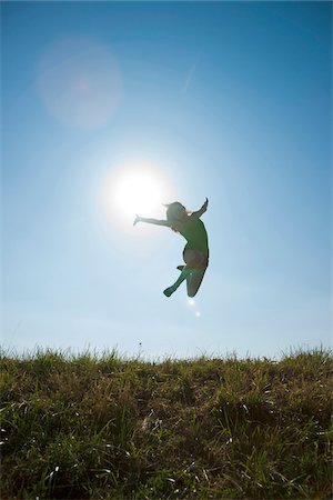 en el aire - Silhouette of Teenaged girl jumping in mid-air over field, Germany Foto de stock - Sin royalties Premium, Código: 600-06899861