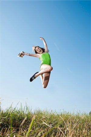Teenaged girl jumping in mid-air over field, Germany Stock Photo - Premium Royalty-Free, Code: 600-06899862