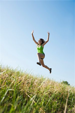 Teenaged girl jumping in mid-air in field, Germany Stock Photo - Premium Royalty-Free, Code: 600-06899878