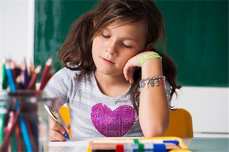 pensive child - Girl sitting at desk in classroom, Germany Stock Photo - Premium Royalty-Free, Code: 600-06899892