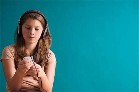 Girl wearing headphones, looking at MP3 player, Germany Foto de stock - Sin royalties Premium, Código: 600-06899919