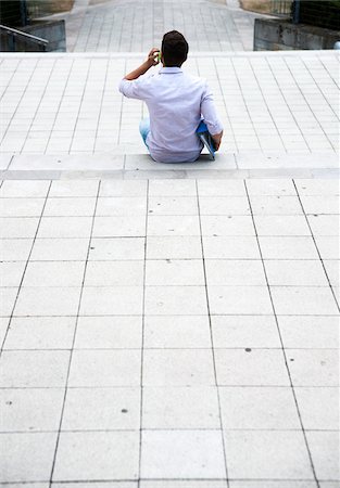 simsearch:600-07110820,k - Backview of young man sitting on steps outdoors, using cell phone, Germany Photographie de stock - Premium Libres de Droits, Code: 600-06899943