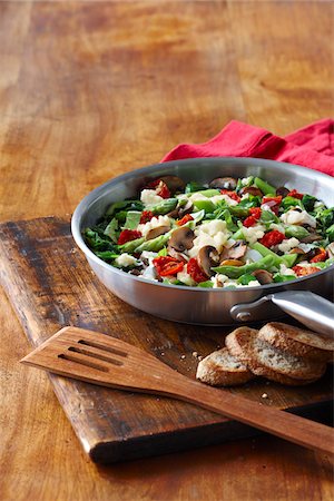 Frying Pan with Vegetable and Egg Scramble for Breakfast with Asparagus, Tomato, Spinach and Mushrooms with Slices of Whole Wheat Toasted Baguette, Studio Shot Stock Photo - Premium Royalty-Free, Code: 600-06892693