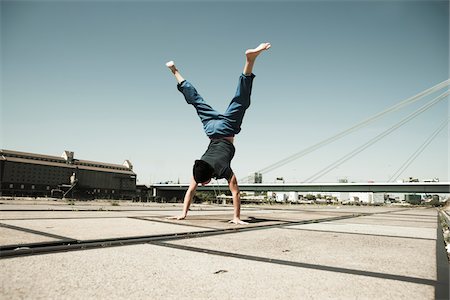 Teenaged boy doing handstand on cement road, freerunning, Germany Photographie de stock - Premium Libres de Droits, Code: 600-06900021