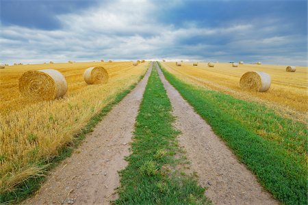 dual track road - Field road through stubble field with straw rolls and rain clouds, Hesse, Germany, Europe Stock Photo - Premium Royalty-Free, Code: 600-06939736