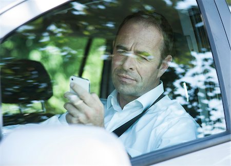 fahrzeug - Businessman using Cell Phone while Driving, Mannheim, Baden-Wurttemberg, Germany Stockbilder - Premium RF Lizenzfrei, Bildnummer: 600-06939746