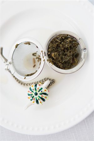 Overhead View of Used Tea Infuser Open with Loose Tea Leaves on Saucer, Studio Shot Stock Photo - Premium Royalty-Free, Code: 600-06967775