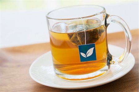 Cup of Tea in Clear Mug with Pyramid Tea Bag and Blue Tag on Wooden Tray, Studio Shot Stock Photo - Premium Royalty-Free, Code: 600-06967776