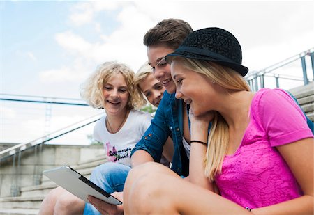 simsearch:600-07584763,k - Group of teenagers sitting on stairs outdoors, looking at tablet computer, Germany Foto de stock - Sin royalties Premium, Código: 600-06961020