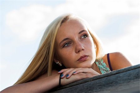 simsearch:600-07311095,k - Portrait of teenage girl sitting on bench outdoors, looking into the distance, Germany Stock Photo - Premium Royalty-Free, Code: 600-06961046