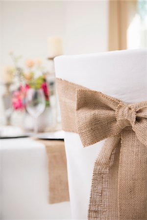 Back view of covered chair with sash and table setting for fine dining Foto de stock - Royalty Free Premium, Número: 600-06961836