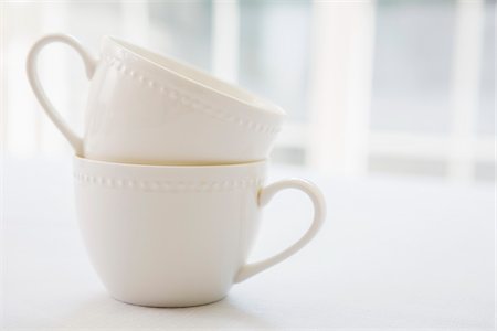 diffused light - Stacked white porcelain teacups, studio shot Stock Photo - Premium Royalty-Free, Code: 600-07067025