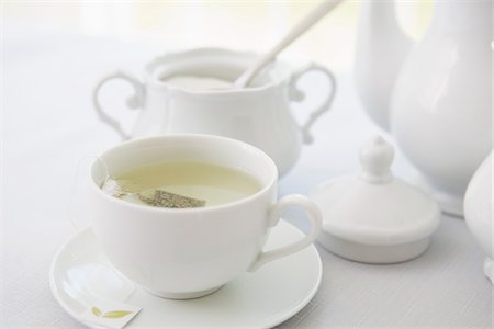 simsearch:600-07066878,k - Cup of tea in porcelain white teacup with saucer, sugar bowl, and teapot, studio shot Stock Photo - Premium Royalty-Free, Code: 600-07067029