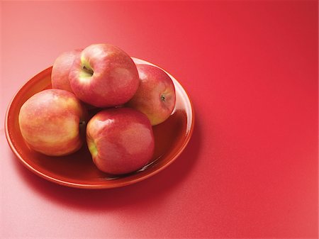simsearch:614-06312093,k - Red apples on plate, red background, studio shot Photographie de stock - Premium Libres de Droits, Code: 600-07067104