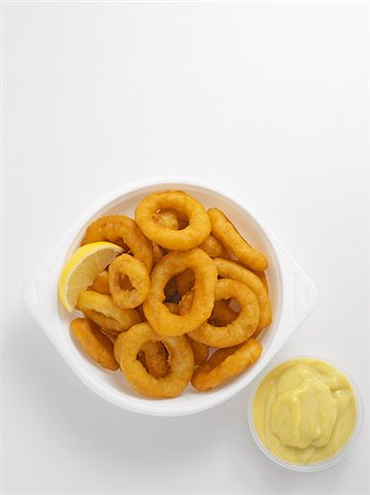 plats grecs - Fried calamari in bowl with condiment on white background, studio shot Photographie de stock - Premium Libres de Droits, Code: 600-07067113