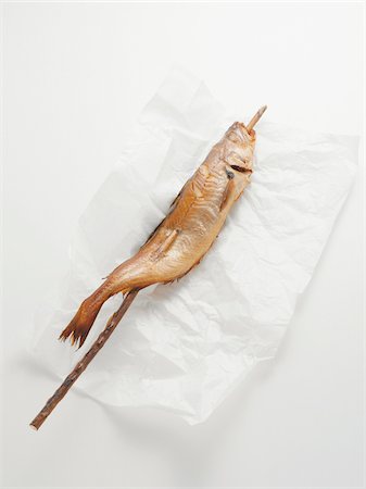 embalaje - Fried mackerel pike fish on stick, on paper wrapper, studio shot Foto de stock - Sin royalties Premium, Código: 600-07067123