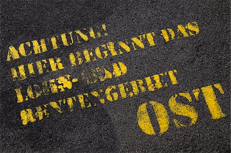 Close-up of German text on paved road (Attention, Here begins the area of wage and pension East), Berlin, Germany Stock Photo - Premium Royalty-Free, Code: 600-07067148