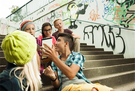 Group of children sitting on stairs outdoors, using tablet computers and smartphones, Germany Foto de stock - Sin royalties Premium, Código: 600-07117170