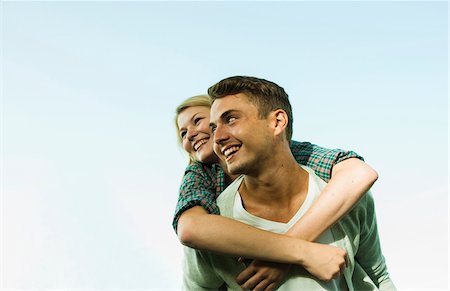 smiling looking up - Young Man giving Young Woman Piggyback Ride, Mannheim, Baden-Wurttermberg, Germany Stock Photo - Premium Royalty-Free, Code: 600-07110813