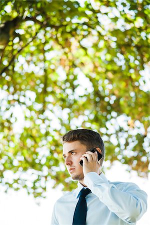 serious young adult portrait - Businessman using Cell Phone Outdoors, Mannheim, Baden-Wurttemberg, Germany Stock Photo - Premium Royalty-Free, Code: 600-07110828