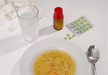 Medications, bowl of chicken soup and glass of water on table, studio shot Photographie de stock - Premium Libres de Droits, Code: 600-07148134