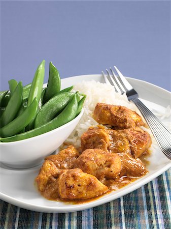 simsearch:600-07067649,k - Butter Chicken and rice on plate with bowl of snap peas, studio shot Stock Photo - Premium Royalty-Free, Code: 600-07148138