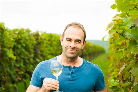 rheinland-pfalz - Portrait of vintner holding glass of wine in vineyard, smiling and looking at camera, Rhineland-Palatinate, Germany Stockbilder - Premium RF Lizenzfrei, Bildnummer: 600-07148209