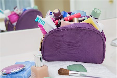 flüßig-mak-up - Women's toiletry and cosmetic travel bag on bathroom counter, filled with toothbrush, lotion, makeup and other beauty products, USA Stockbilder - Premium RF Lizenzfrei, Bildnummer: 600-07199729