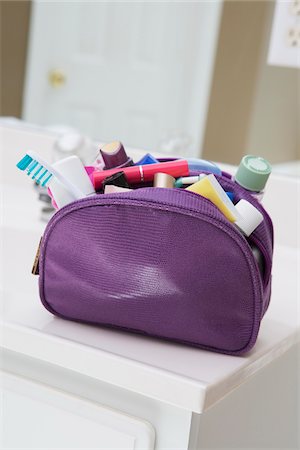 pacchetto - Women's toiletry and cosmetic travel bag on bathroom counter, filled with toothbrush, lotion, make-up and other beauty products, USA Fotografie stock - Premium Royalty-Free, Codice: 600-07199730