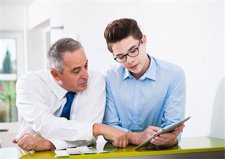 people office two people copy space - Businessman and apprentice looking at talet computer in office, Germany Stock Photo - Premium Royalty-Free, Code: 600-07199803