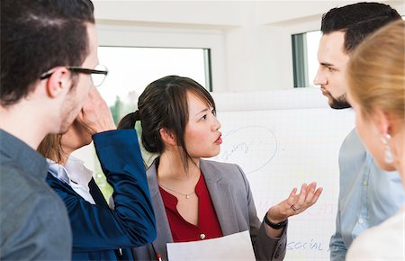 Close-up of young business people in disucssion in office, Germany Photographie de stock - Premium Libres de Droits, Code: 600-07199947