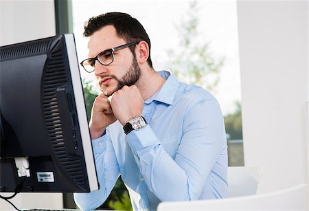 simsearch:700-07278864,k - Close-up of young businessman looking at computer monitor in office, Germany Stock Photo - Premium Royalty-Free, Code: 600-07199953