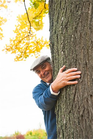 Portrait of Senior Man Standing behind Tree, Mannheim, Baden-Wurttemberg, Germany Stock Photo - Premium Royalty-Free, Code: 600-07192133