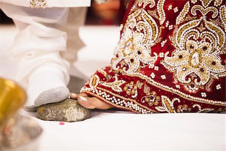 Bride and Groom Stepping on Stone during Hindu Wedding Ceremony, Toronto, Ontario, Canada Stock Photo - Premium Royalty-Free, Code: 600-07204153