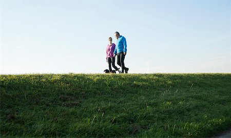 Couple Walking Dog Outdoors, Mannheim, Baden-Wurttemberg, Germany Stock Photo - Premium Royalty-Free, Code: 600-07237892