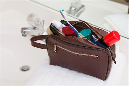 packing for travel - Men's Toiletry Travel Bag on Bathroom Counter filled with Personal Hygiene Products Stock Photo - Premium Royalty-Free, Code: 600-07232297