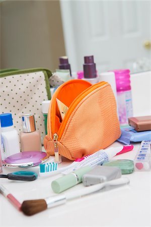 packing for vacation - Women's Toiletry Travel Bag on Bathroom Counter filled with Personal Hygiene Products Stock Photo - Premium Royalty-Free, Code: 600-07232301