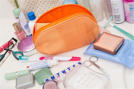 packing for travel - Women's Toiletry Travel Bag on Bathroom Counter filled with Personal Hygiene Products Stock Photo - Premium Royalty-Free, Code: 600-07232302