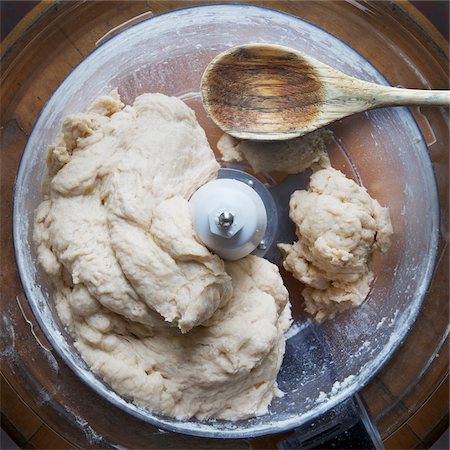 Close-up of uncooked pie dough in food processor with wooden spoon. studio shot Photographie de stock - Premium Libres de Droits, Code: 600-07240807