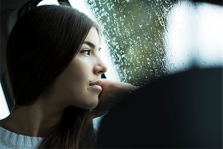 Portrait of young woman sitting inside car and looking out of window and day dreaming on overcast day, Germany Photographie de stock - Premium Libres de Droits, Code: 600-07278932