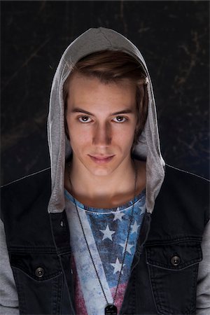 Portrait of teenage boy wearing hoodie and looking at camera, studio shot Foto de stock - Sin royalties Premium, Código: 600-07311016