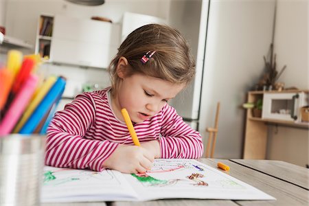 Girl Sitting at Table and Colouring Pictures Foto de stock - Sin royalties Premium, Código: 600-07311314