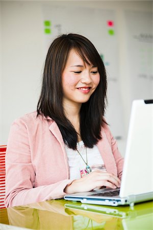 Young woman working on laptop computer in office, Germany Stock Photo - Premium Royalty-Free, Code: 600-07311397