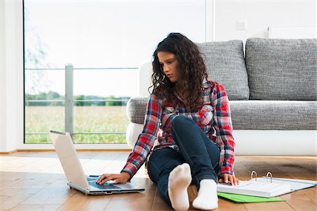 simsearch:600-06355199,k - Teenage girl sitting on floor next to sofa, using laptop computer, Germany Stock Photo - Premium Royalty-Free, Code: 600-07311417