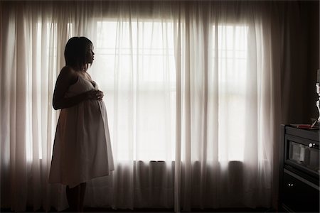 Silhouette of Pregnant Woman Looking out Window Photographie de stock - Premium Libres de Droits, Code: 600-07311586