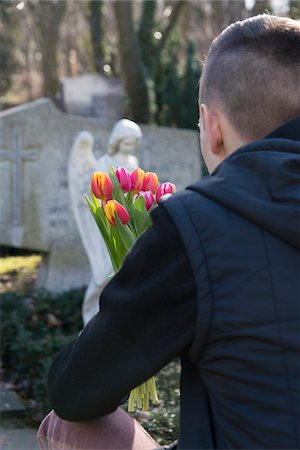 simsearch:614-06719568,k - Teenager in front of Grave Stones with Tulips in Cemetery Foto de stock - Royalty Free Premium, Número: 600-07351346